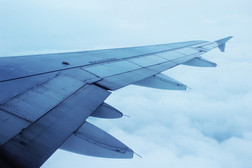 Fototapeta na wymiar Wing of the plane cloudy sky background