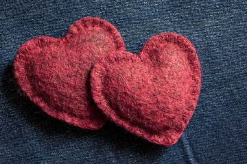 two soft hearts together on a jeans background, a romantic concept of love and long happiness together with your beloved partner