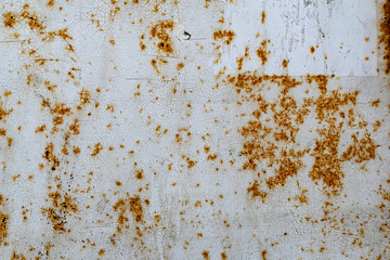 Metal surface with white paint that has passed temporary damage, a lot of formed, red rust. Textured background with traces of destruction and deformation