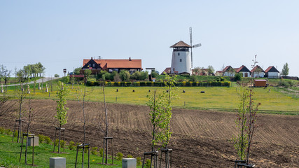 Fototapeta na wymiar Bukovany, Czech Republic / Southern Moravia - April 18, 2020: Bukovany wind mill and orchard with field