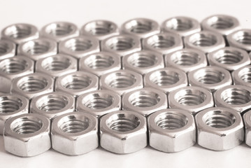 Screw, bolt and nut in black and white for industrial background. Pattern of metal nuts. Metal nuts on white background. Chromed nuts isolated. Steel nuts isolated. Tools for work