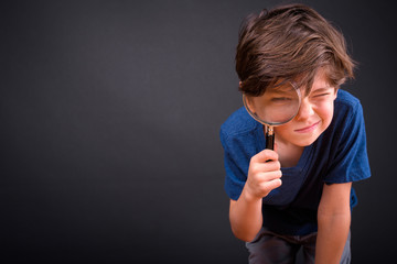 Portrait of young handsome boy using magnifying glass - 341324248