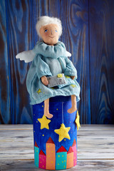 Fototapeta na wymiar Soft textile handmade toy doll of Angel with letters in his hands. Cute fairy angel of good news in blue clothes.