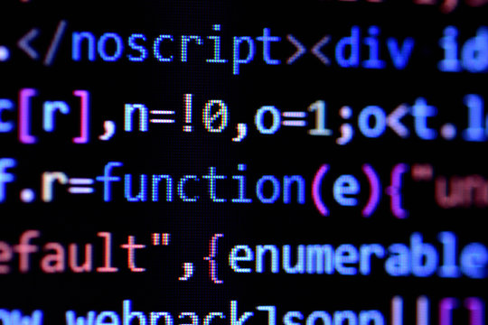 Close-up of minified javascript file. Computer programming source code for HTML website development.