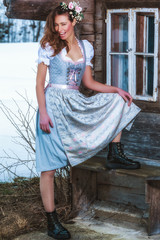Schöne langhaarige Frau im Dirndl mit locken und Blumen im Haar
