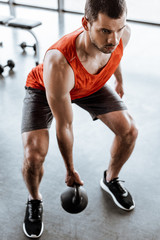 Fototapeta na wymiar selective focus of strong man exercising with heavy dumbbell