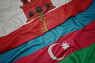 waving colorful flag of azerbaijan and national flag of gibraltar