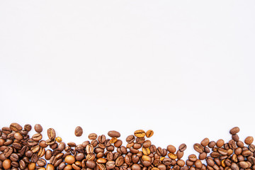 coffee beans evenly sprinkled on a white background