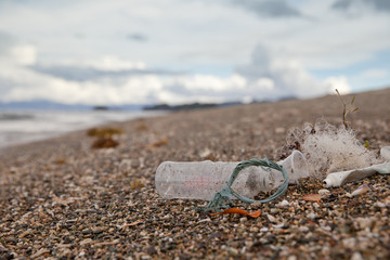 Beach pollution. Plastic bottles and other trash on sea beach. Ocean pollution.