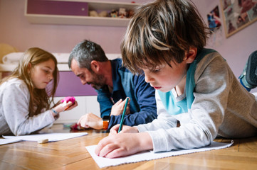 Children at home drawing with their parents