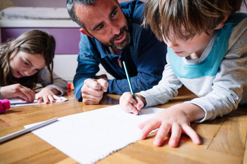 Children at home drawing with their parents