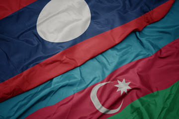 waving colorful flag of azerbaijan and national flag of laos.