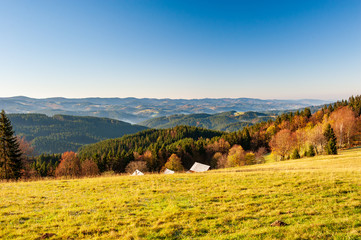 Warm light sunset panorama view of  Beskydy mountains with fog in the valley and blue cloudless...