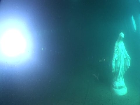 mother Mary statue underwater in an airplane wreck  ocean scenery
