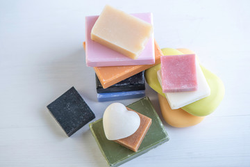 selection of colorful  natural rose olive orange carbon coal charcoal black soap bar block isolated on white background 