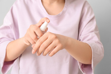 Woman with disinfectant on grey background. Concept of epidemic