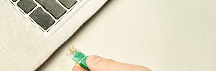 Hand holding lan cable with RG45 connector for plug to laptop