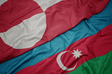 waving colorful flag of azerbaijan and national flag of greenland.