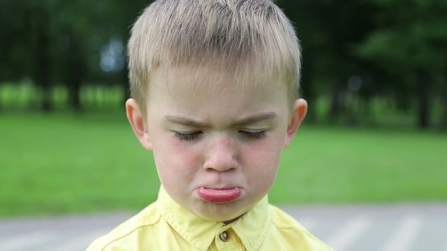 Child is sad boy, then becomes cheerful and laughs, close-up.