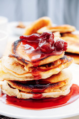 Appetizing pancakes with jam. Photo of pancakes with cherries. A stack of pancakes.