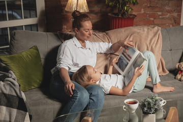 Book reading. Mother and daughter during self-insulation at home while quarantined, family time...