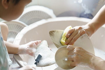 Obraz na płótnie Canvas Asian boy help his mother washing and cleaning dirty fan