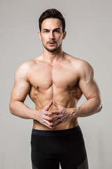 portrait of a muscular athlete with a naked torso on a light white background