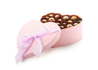 Heart-shaped box with delicious candies on white background
