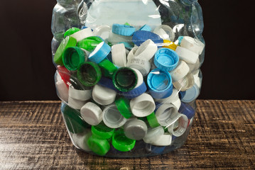 Many plastic jams close up. Texture of bottle caps on black background.