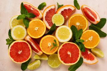 Orange, lemon, grapefruit, mandarin and lime on trendy pink stone or concrete table background. Citrus fruits. Top view, flat lay