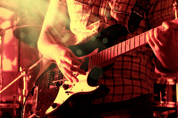 Life style image of close up young male guitarist hand, playing electric guitar