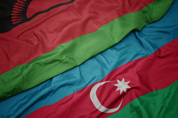 waving colorful flag of azerbaijan and national flag of malawi.