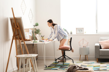 Young female designer working at home