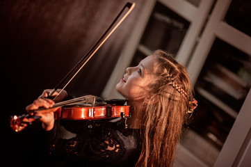 Cute girl plays the violin, low key, quarantine class idea. Music concept
