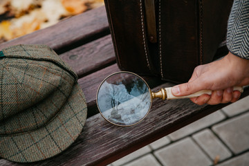 Large round magnifier on long handle in detective hand