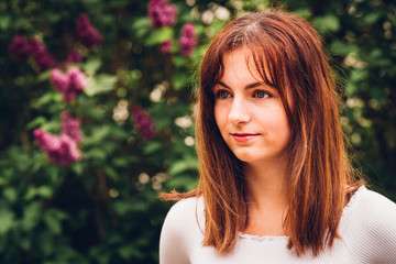 Fototapeta premium portrait d'une jeune femme aux cheveux bruns cuivrés dorés et aux yeux bleus 