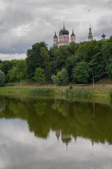 Fototapeta na wymiar Domes of the monastery are reflected in the lake of Theophany Park. Kiev, Ukraine
