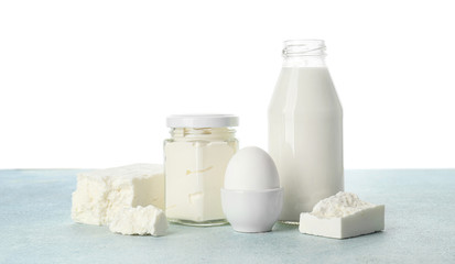 Different dairy products on table against white background