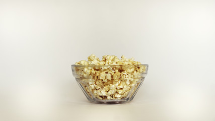 Close up of isolated transparent bowl with popcorn on white background copy space