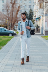 Bearded stylish indian man outdoors takes away coffee