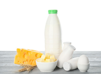 Different dairy products on table against white background