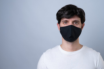 Man in a black medical mask, isolated on a gray background