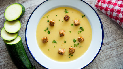 Cream of zucchini  with croutons, oil and fresh vegetables
