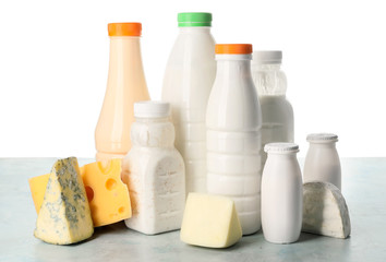 Different dairy products on table against white background