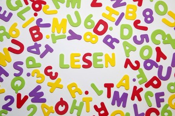 german word LESEN - reading - and seamless pattern with letters of the alphabet and numbers in random order on a white background. Education and Back to school concept