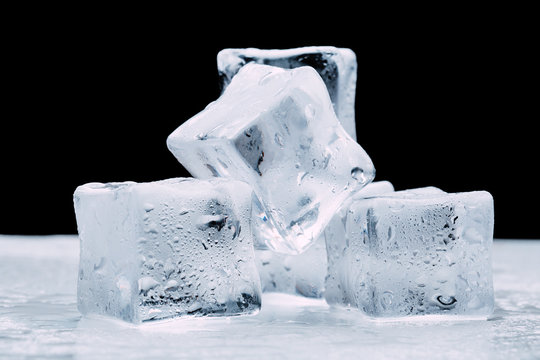 wet ice cubes with drops on a dark black background