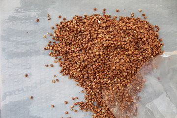 brown grits, buckwheat on a gray background with spots.
