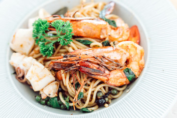 drunken spaghetti with seafood on white plate is modern Thai fusion food