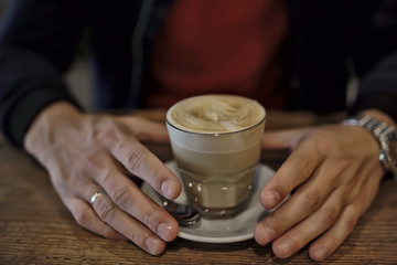 cup of cappuccino in a cafe in hands, coffee in a restaurant interior