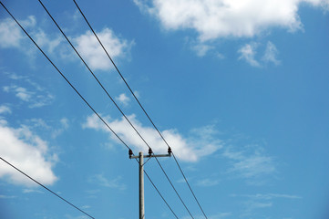 Pylon of a power line with outgoing electric wires againts a cloud blue sky                        ...